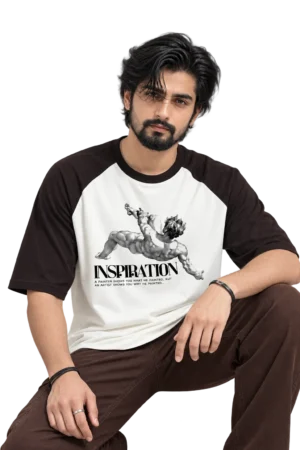 Male model wearing a loose cream and dark raglan T-shirt featuring a classical figure and “INSPIRATION” graphic