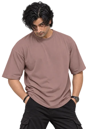 Male fashion model wearing a loose dusty mauve oversized T-shirt with curly black hair and dark cargo pants