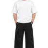 Indian male model wearing relaxed black wide-leg pants with an elastic drawstring waist, paired with a white oversized T-shirt and white sneakers.
