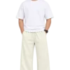 Wide-Leg Relaxed Fit Pants – Bairaagi Male model wearing cream-colored wide-leg relaxed fit pants with an elastic drawstring waist, styled with a white oversized T-shirt and white sneakers.